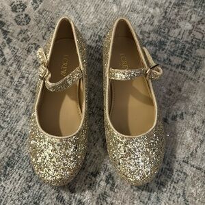 Girls hold sparkle shoes